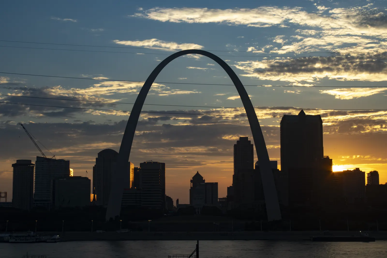 The Gateway Arch and the downtown St. Louis skyline at sunset, seen across the Mississippi River